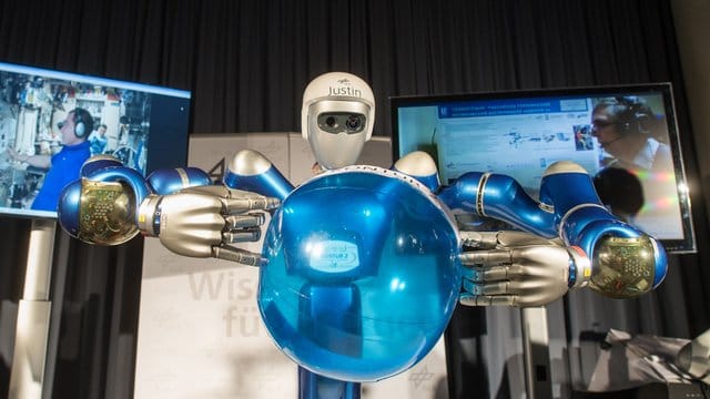 Der Roboter heißt Justin und balanciert einen blauen Ball.