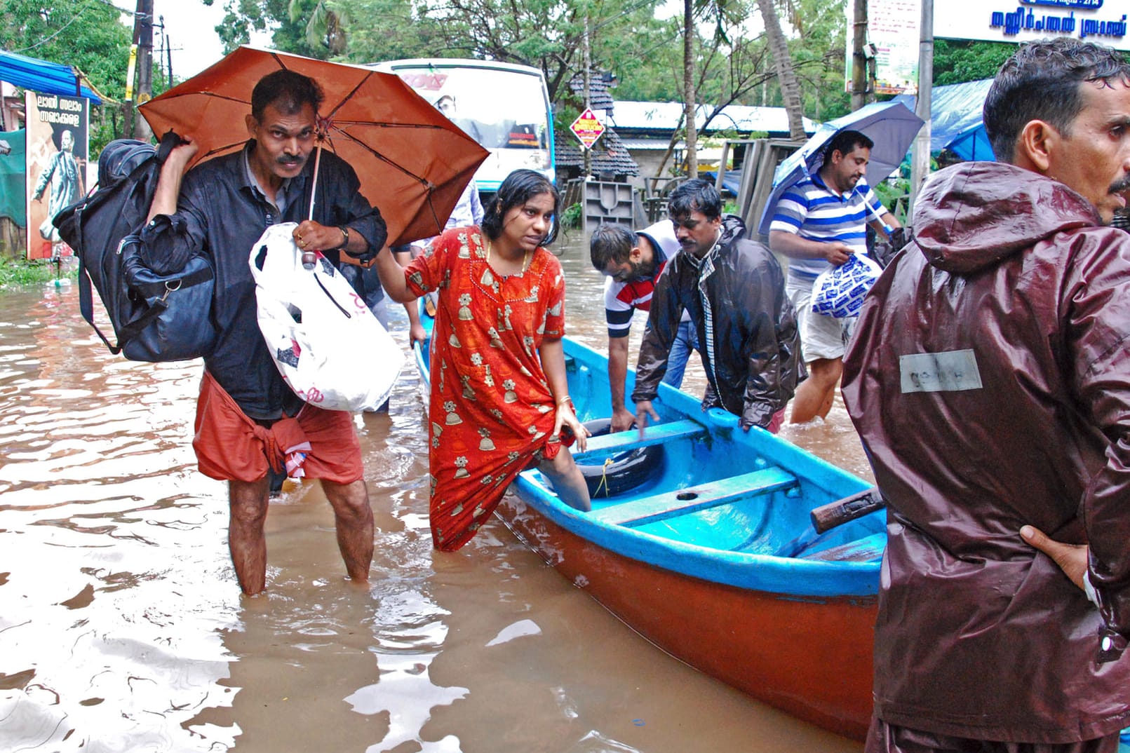 Flutopfer werden aus einem überschwemmten Gebiet evakuiert: Der indische Bundesstaat Kerala leidet unter dem schwersten Monsunregen seit Jahrzehnten.