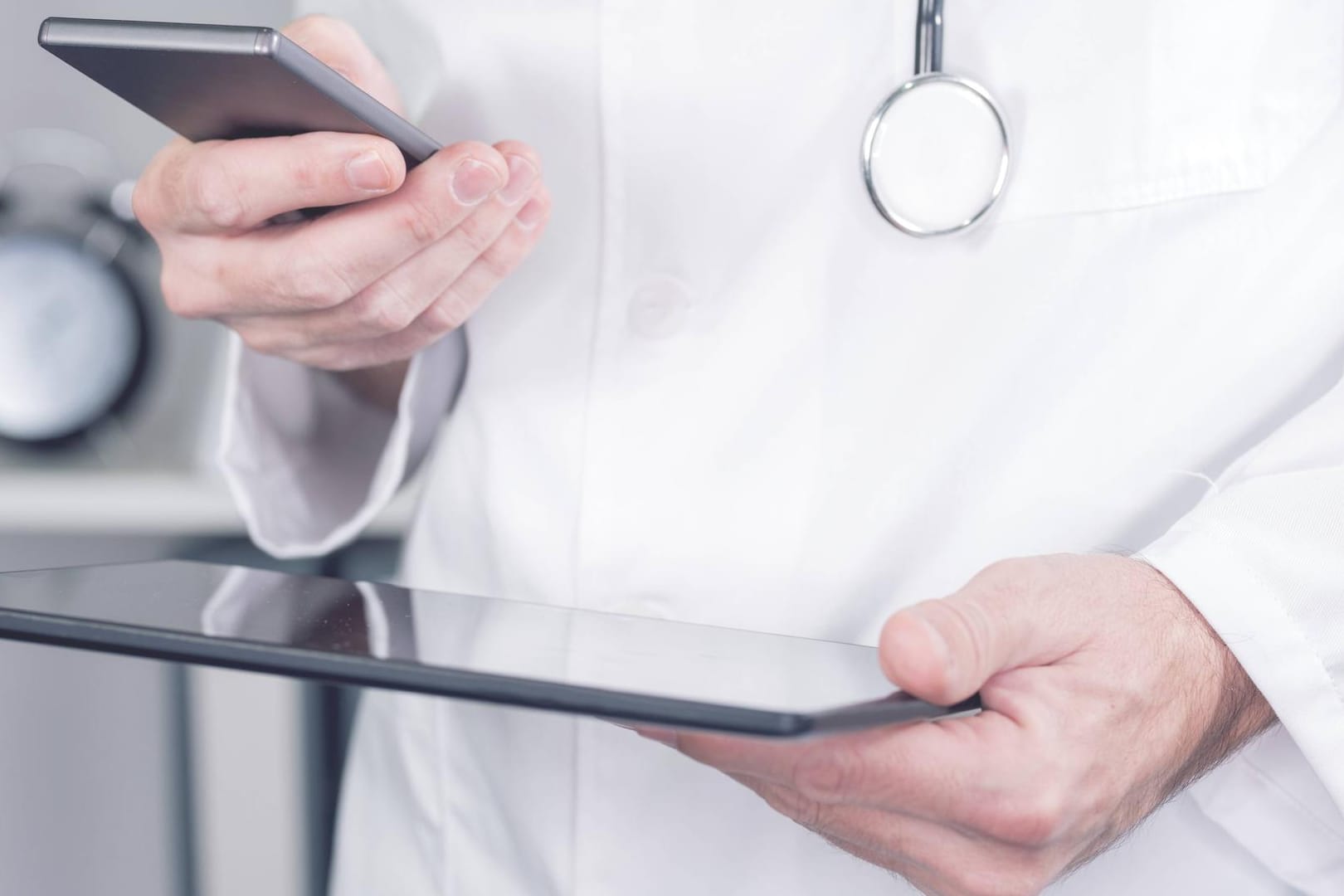 Arzt beim Nutzen eines Smartphones und Tablet-PCs (Symbolbild): Ein Arzt soll von seinen Patientinnen Sex als Gegenleistung für das Verschreiben von Medikamenten verlangt haben.