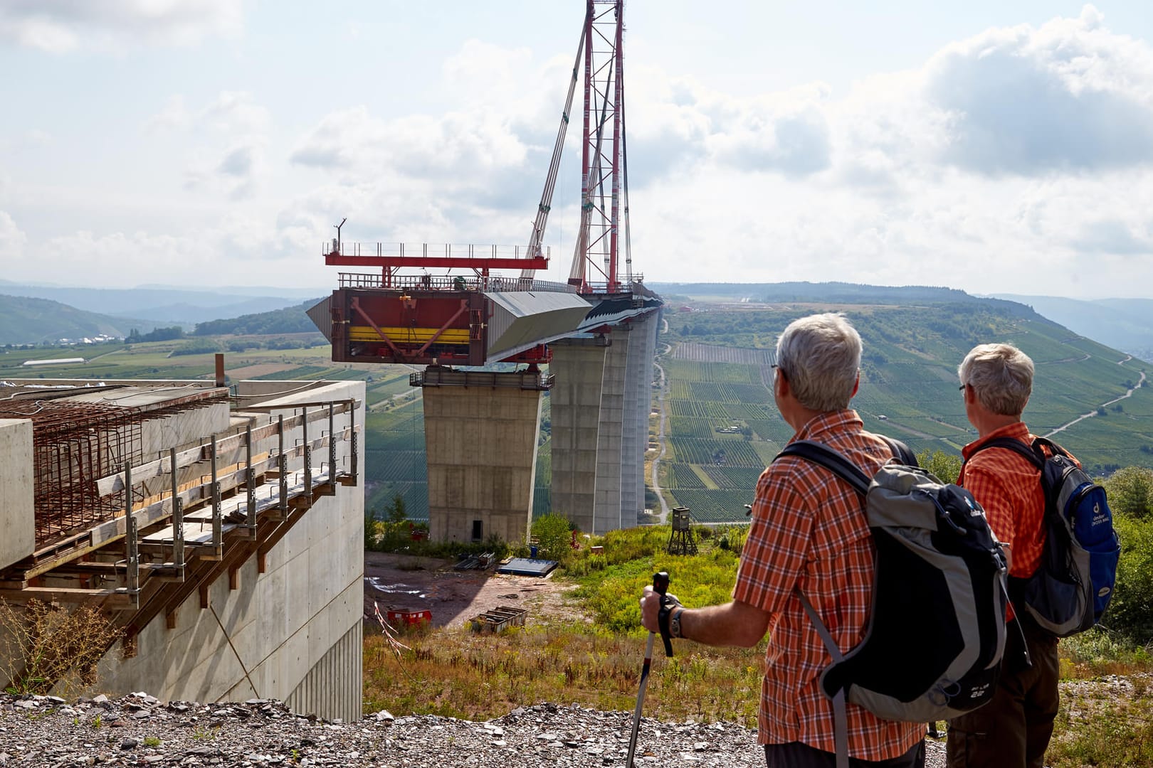 Wanderer stehen vor der unfertigen Hochmoselbrücke: Derzeit läuft die Verschubphase für das letzte rund 231 Meter lange Teilstück, das den Hunsrück mit der Eifel verbinden wird.