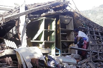 Lombok kommt nicht zur Ruhe: Eine Frau sammelt Habseligkeiten in der Ruine ihres durch ein Erdbeben zerstörten Hauses.
