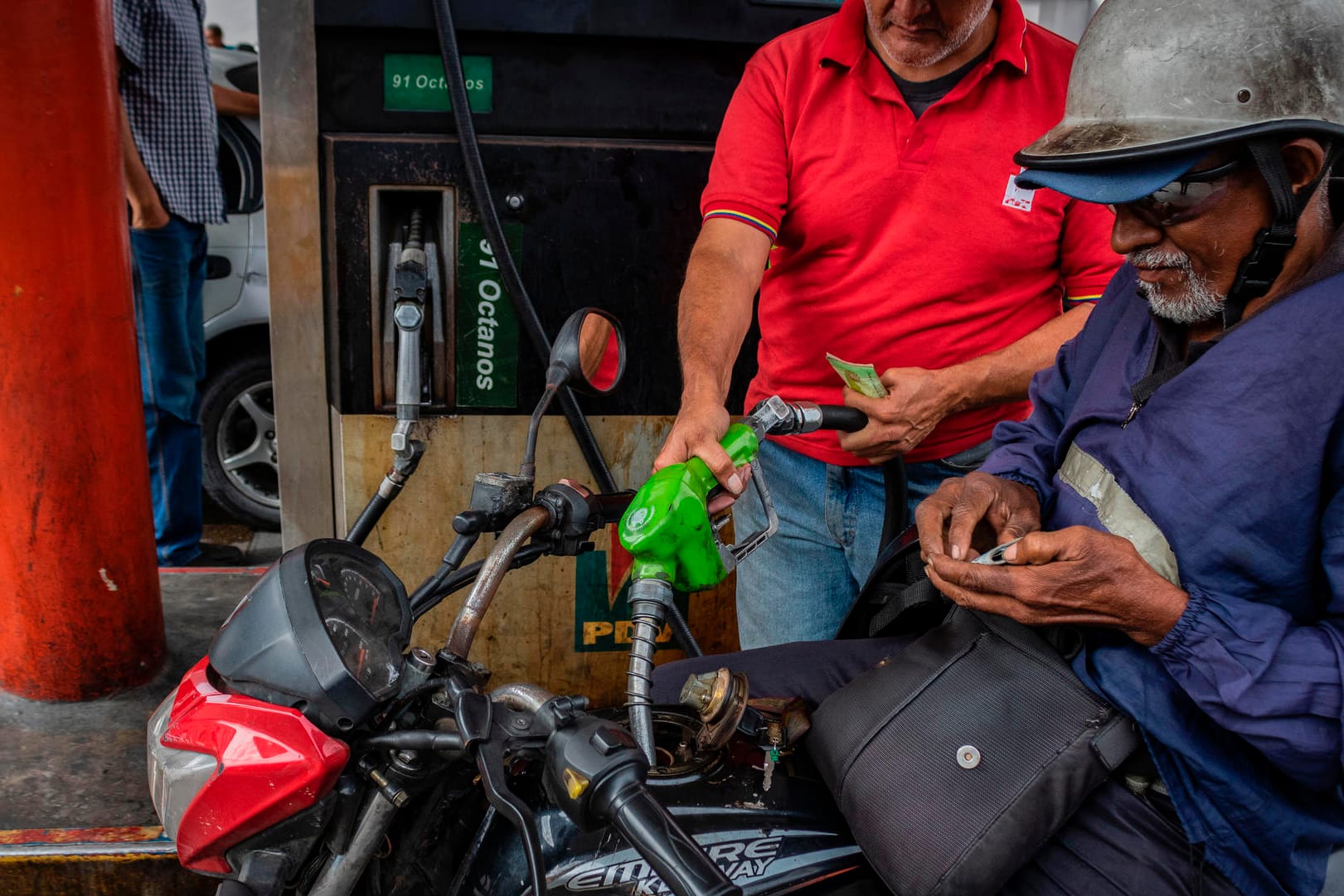 Ein Motorradfahrer beim Tanken in Caracas: Bisher mussten die Einwohner für Benzin fast nichts zahlen.