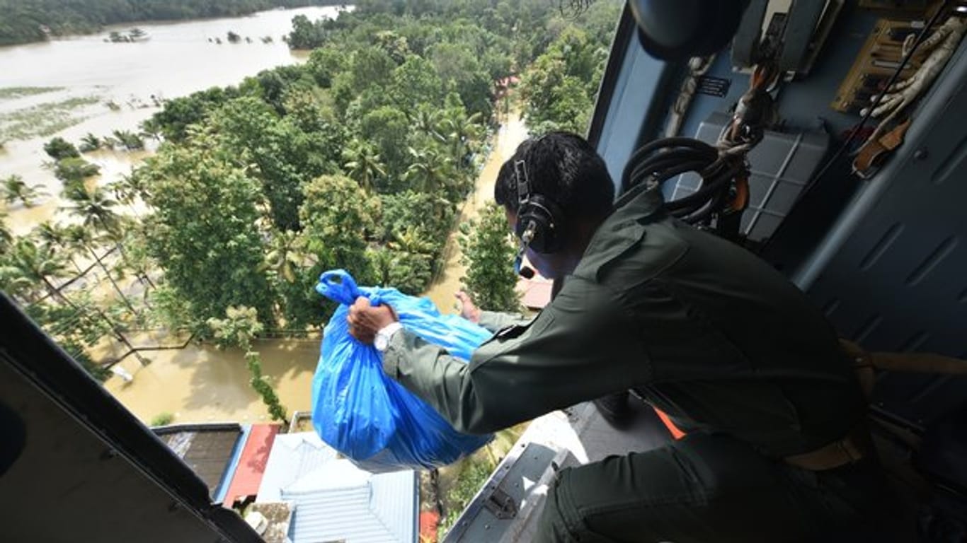 Ein Soldat verteilt Hilfsgüter aus einem Helikopter.