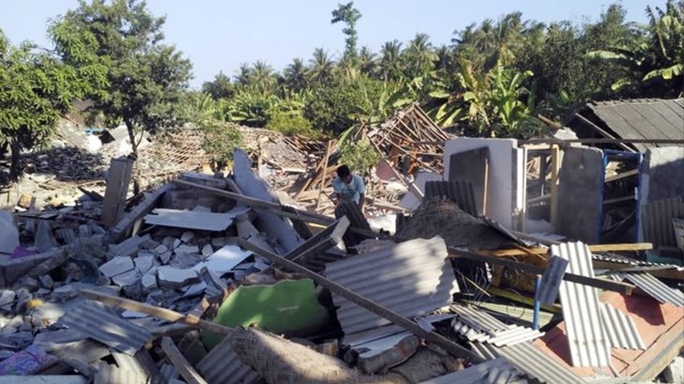 Ein Mann durchsucht die Trümmer zerstörter Häuser nach dem jüngsten Erdbeben auf der Insel Lombok.