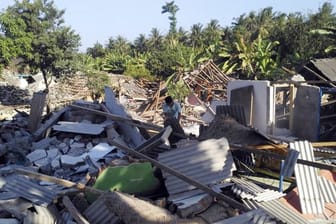 Ein Mann durchsucht die Trümmer zerstörter Häuser nach dem jüngsten Erdbeben auf der Insel Lombok.