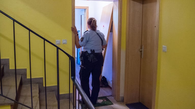 Düsseldorf: Eine Polizistin steht im Eingang einer Wohnung, die Spezialkräfte im Rahmen einer Fahndung durchsuchten. Ein Mann hatte auf der Straße eine Frau tödlich verletzt.