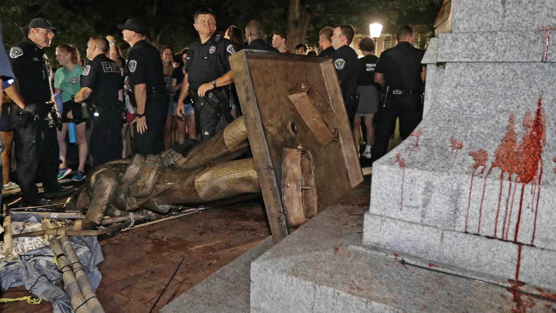 Polizisten bewachen die umgestürzte Statue eines Konföderierten: Die Aktion sei sehr gefährlich gewesen, kritisierte die Universität.