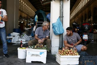 Gemüsehändler vor einem Fischmarkt in Athen: Die Schulden Griechenlands sind noch immer enorm.