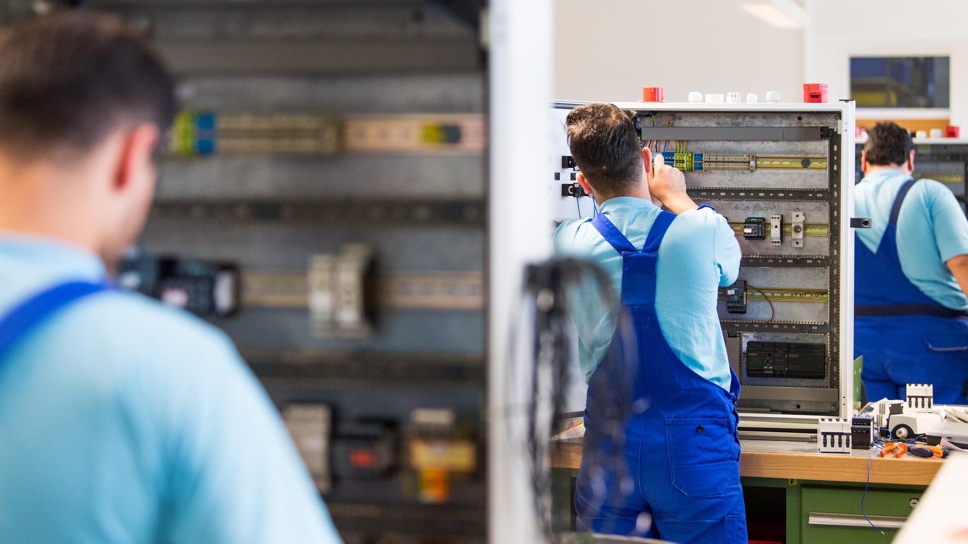 Drei junge Flüchtlinge arbeiten in einem Ausbildungszentrum von Siemens: Laut Bundesagentur für Arbeit haben 28.000 Flüchtlinge eine Lehre angefangen.