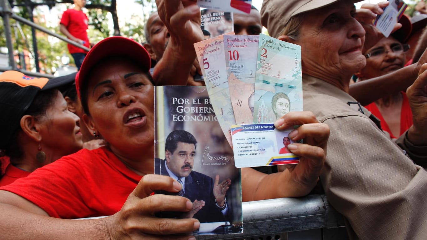 Anhänger der Regierung jubeln nach der Ausgabe neuer Banknoten und der "Carnet de la Patria", einem Ausweisdokument, das unter Präsident Maduro eingeführt wurde. Doch ob die Reformen wirken, wird bezweifelt.