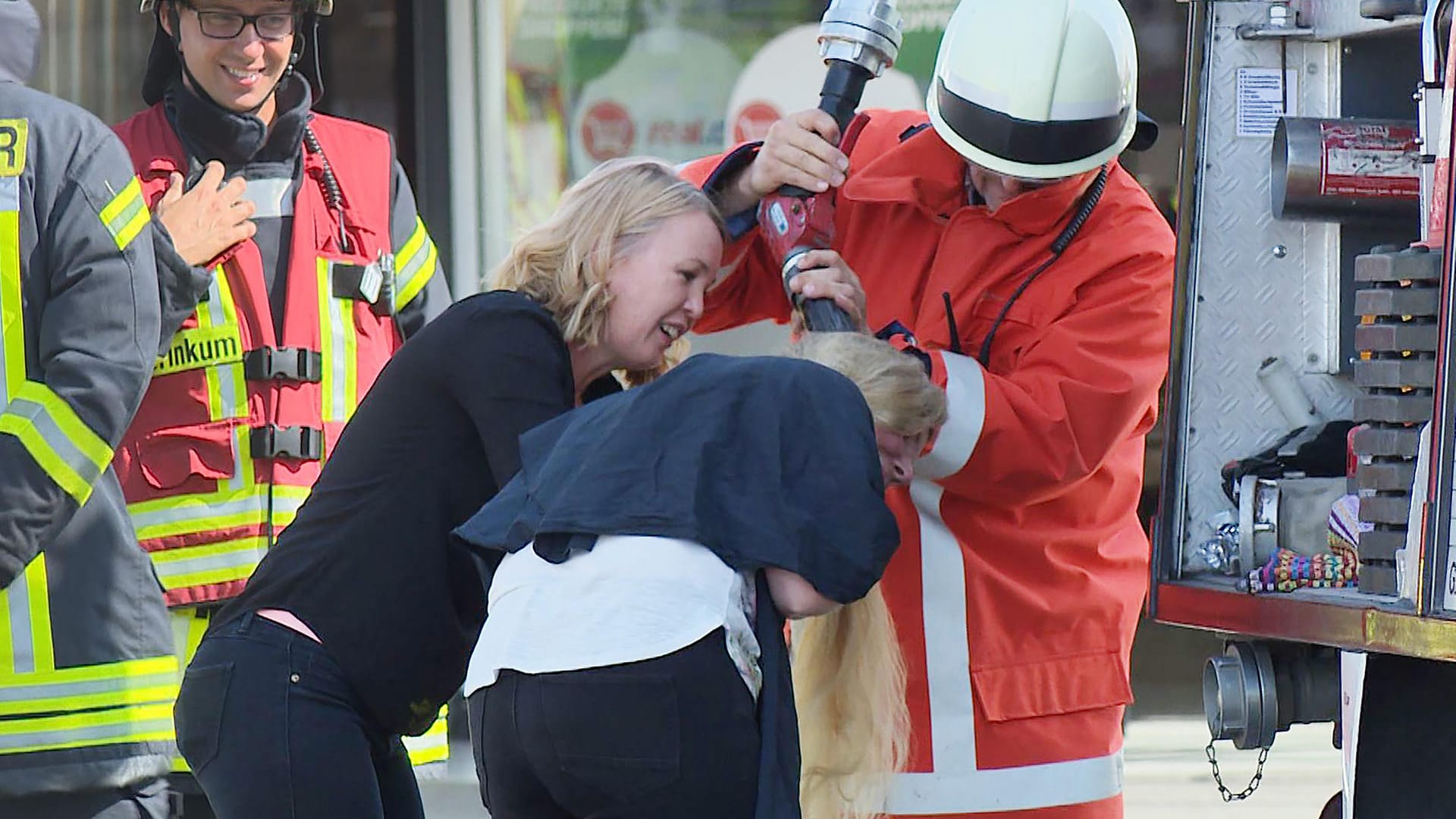 Ein Feuerwehrmann wäscht einer Friseurkundin die Haare aus: Die Feuerwehr eilte bei einem Brand in einem Supermarkt auch einer Friseurkundin zu Hilfe. Ein Feuerwehrmann wäscht einer Friseurkundin die Haare aus: Die Feuerwehr eilte bei einem Brand in einem Supermarkt auch einer Friseurkundin zu Hilfe.