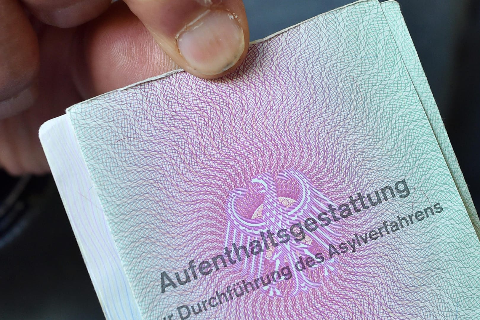 Ein Mann aus Syrien zeigt in der Gemeinschaftsunterkunft für Flüchtlinge seine Aufenthaltsgestattung: Insgesamt wurden an der Grenze zu Österreich seit Mitte Juni 150 Migranten angetroffen, die schon in einem anderen EU-Land einen Asylantrag gestellt haben.