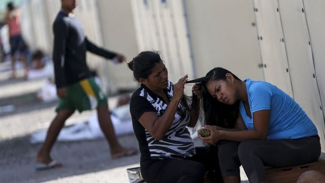 Eine Migrantin frisiert eine Freundin im Flüchtlingslager "Abrigo Rondon 1". Eine Migrantin frisiert eine Freundin im Flüchtlingslager "Abrigo Rondon 1".
