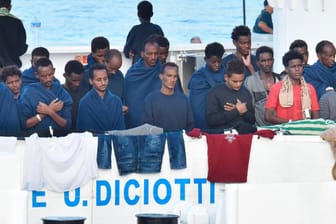 Migranten beten an Bord des italienischen Küstenwachschiffes «Diciotti» im Hafen von Catania: Die EU-Kommission bemühe sich weiter um eine Lösung für die Menschen auf der «Diciotti», sagte ein Sprecher in Brüssel. Italien hatte Brüssel am Sonntag aufgefordert, EU-Länder zu finden, die bereit sind, einige der Migranten zu übernehmen.