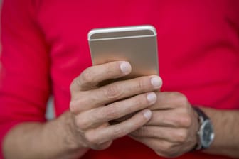Mann beim Verfassen einer Nachricht auf dem iPhone (Symbolbild): Es gibt verschiedene Möglichkeiten einzustellen, wer und wann Bestätigung bekommt, wenn man Nachrichten gelesen hat.