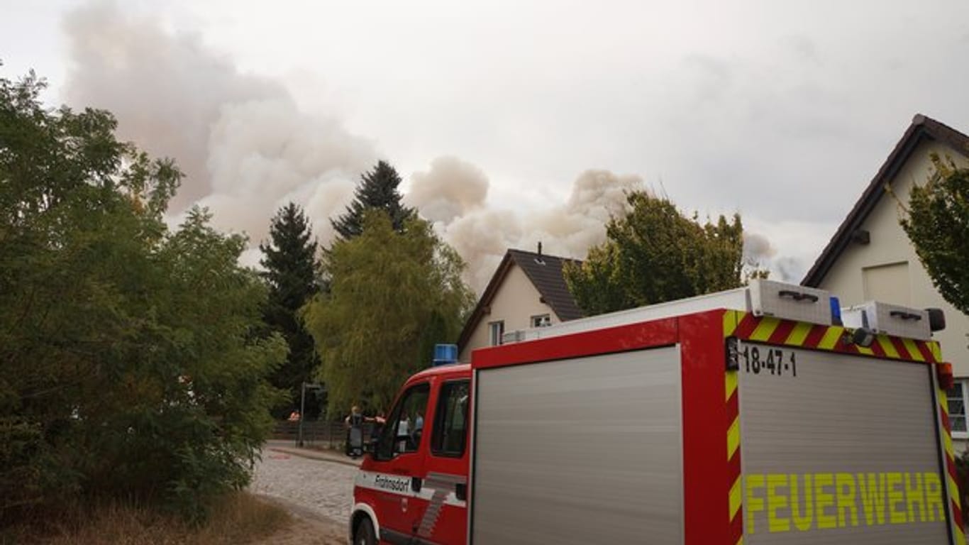 Rauch steigt hinter Häusern in Frohnsdorf auf.