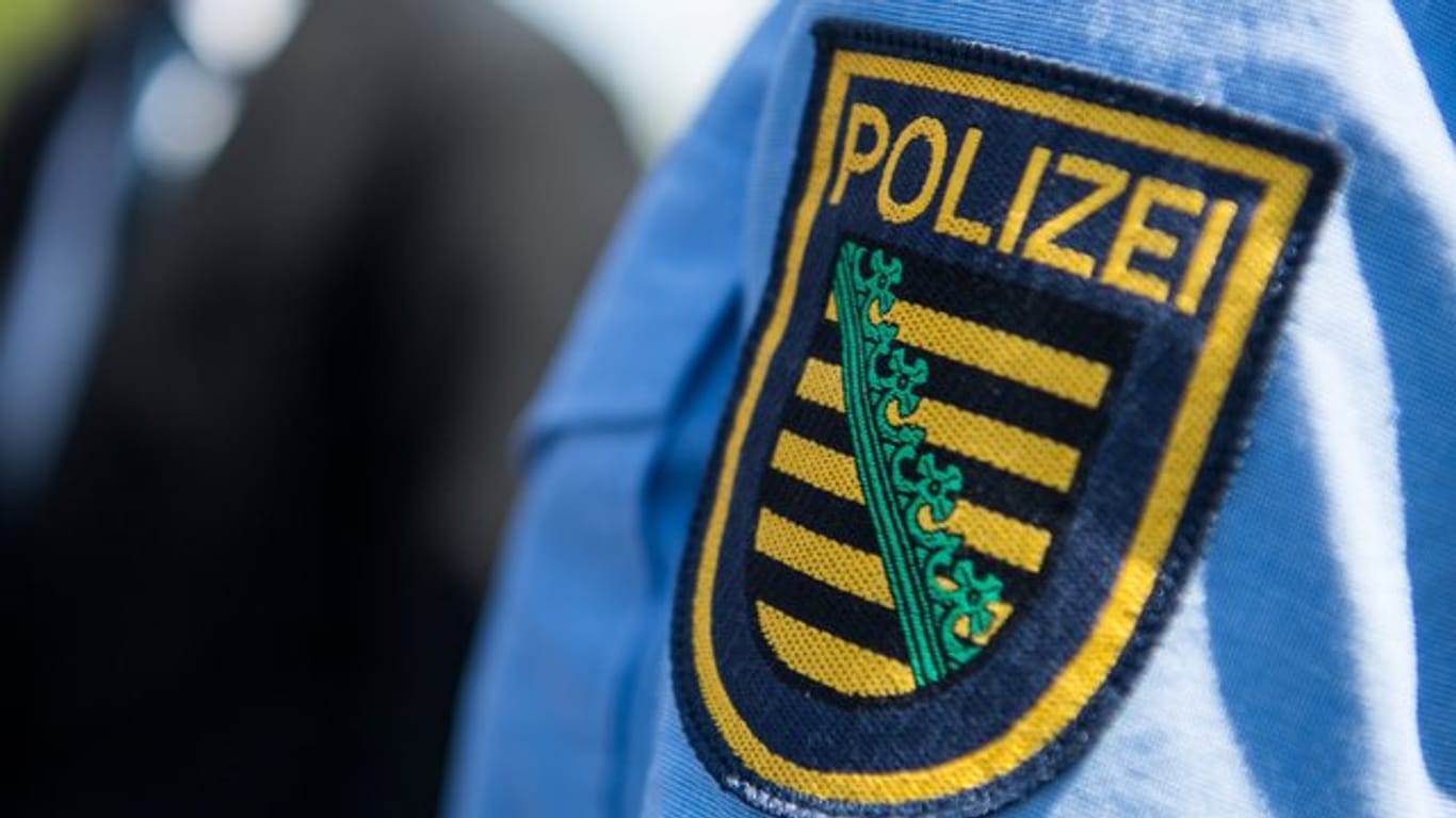 Das Abzeichen der sächsischen Polizei an der Uniform eines Beamten.