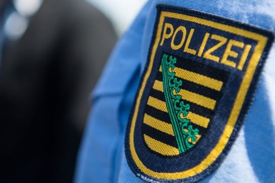 Das Abzeichen der sächsischen Polizei an der Uniform eines Beamten.