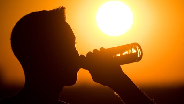 Ein junger Mann genehmigt sich am Abend ein Bier.