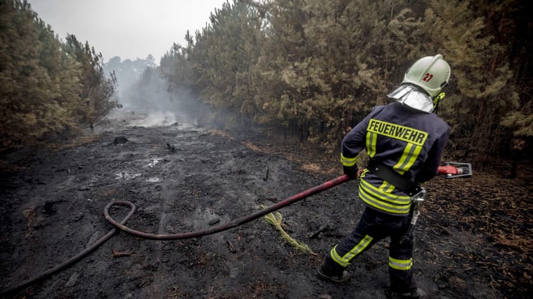 Ein Feuerwehrmann im Einsatz: Die Einsatzkräfte kämpfen mit einem rund 400 Hektar großen Waldbrand in Brandenburg.
