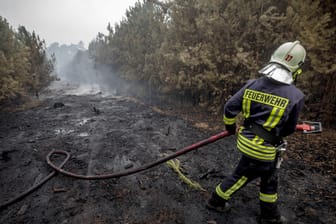 Ein Feuerwehrmann im Einsatz: Die Einsatzkräfte kämpfen mit einem rund 400 Hektar großen Waldbrand in Brandenburg.