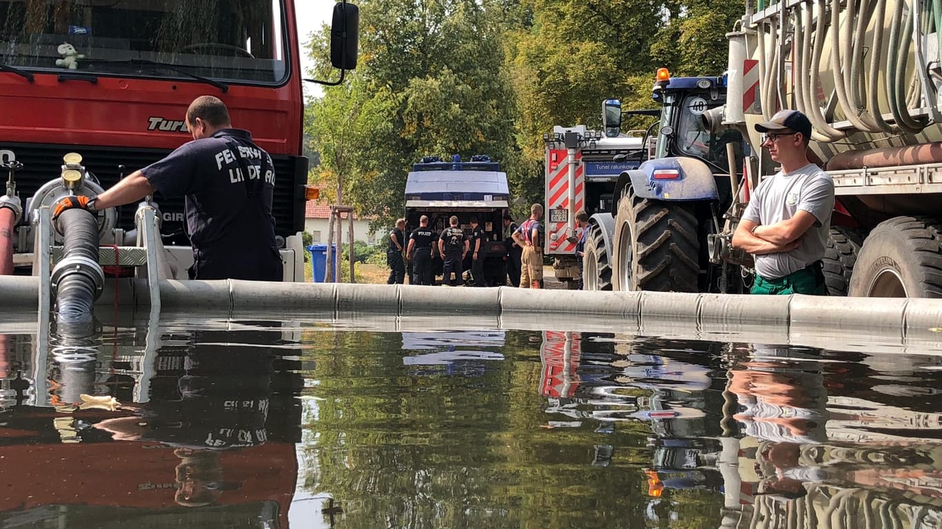 Wassertanks füllen: Um einen Wasserbehälter sammelten sich Feuerwehrfahrzeuge, Wasserwerfer der Polizei und Schlepper mit Wasserfässern.