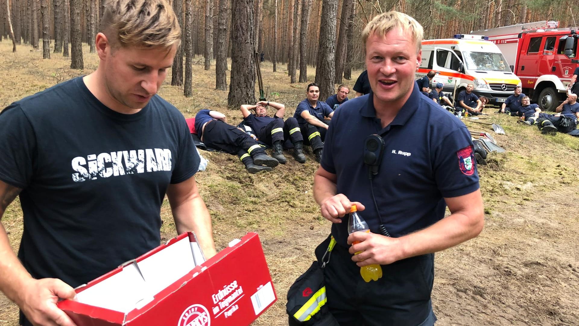 Eine Kiste mit Süßigkeiten: Marcus Faustmann bei Einsatzkräften im Wald.