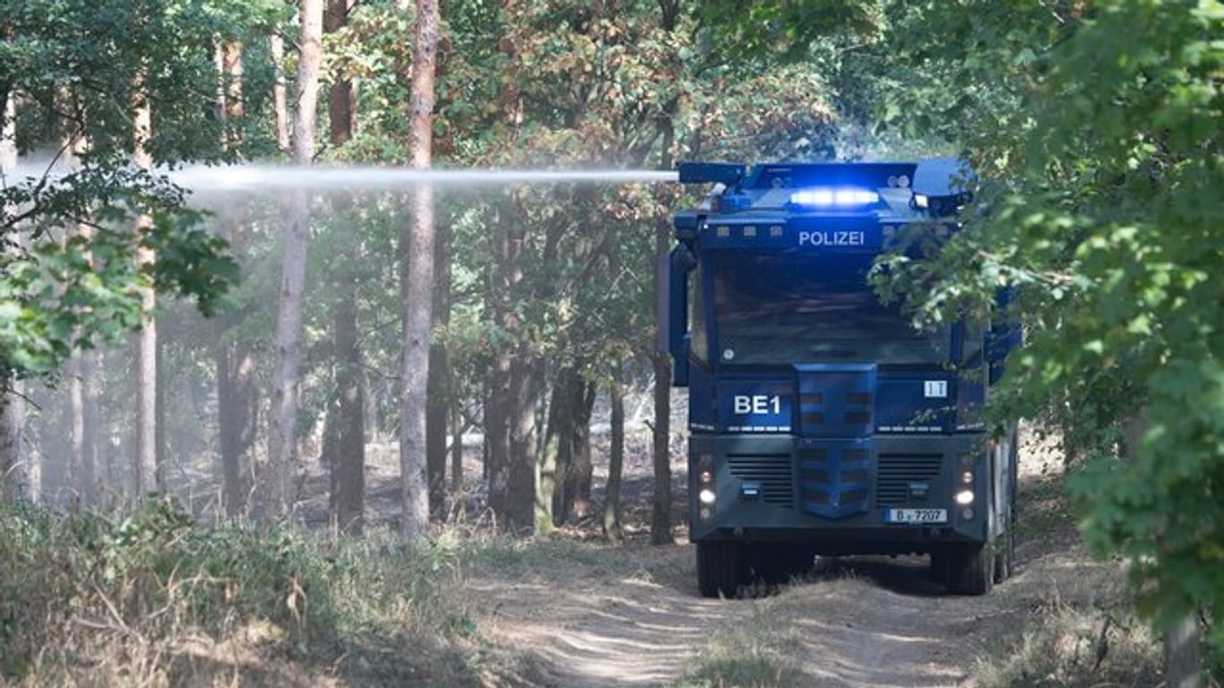 Ein Wasserwerfer der Polizei löscht ein Brandnest in einem Waldstück bei Frohnsdorf.
