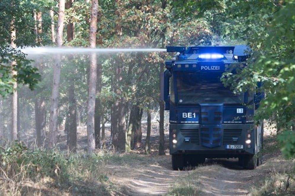Ein Wasserwerfer der Polizei löscht ein Brandnest in einem Waldstück bei Frohnsdorf.