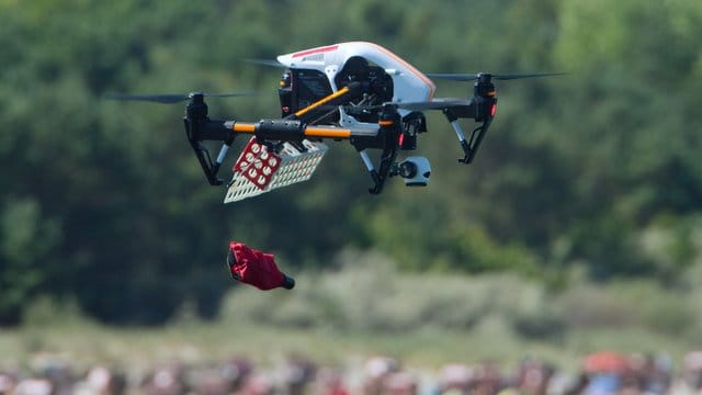 Ein Rettungscopter der DRK-Wasserwacht wirft am Strand von Usedom eine Schwimmhilfe ab.