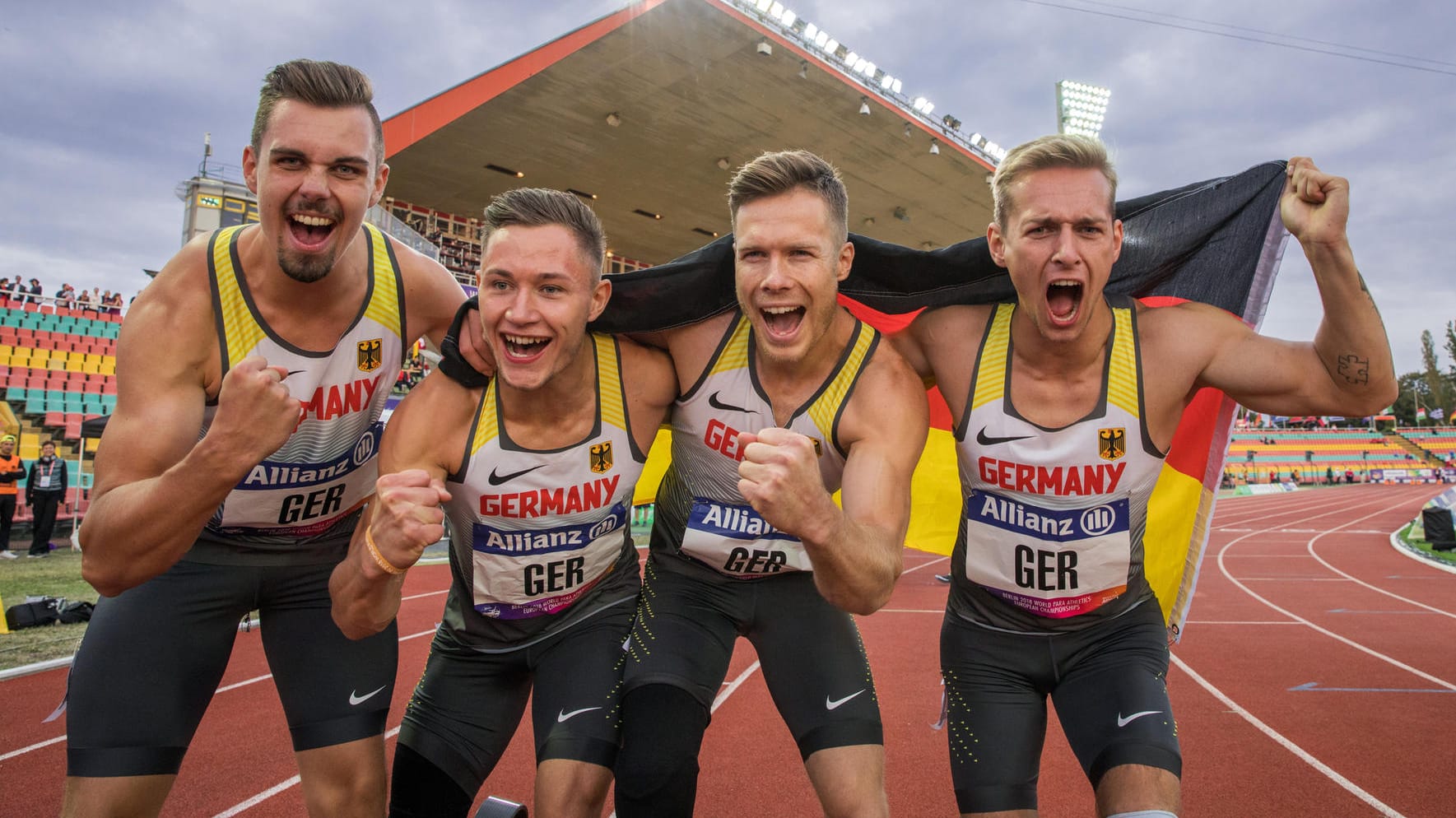 Reinhold Bötzel (v.l.), Felix Streng, Markus Rehm und Johannes Floors feiern im Ziel ihre Goldmedaille in der Staffel.