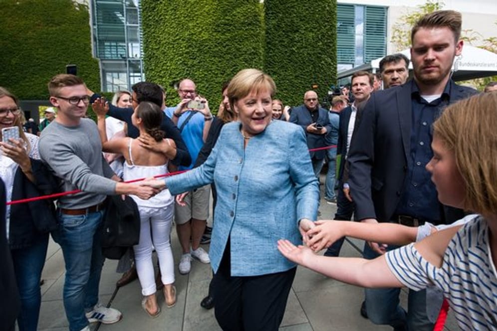 Angela Merkel begrüßt Besucher auf dem Gelände des Bundeskanzleramts.