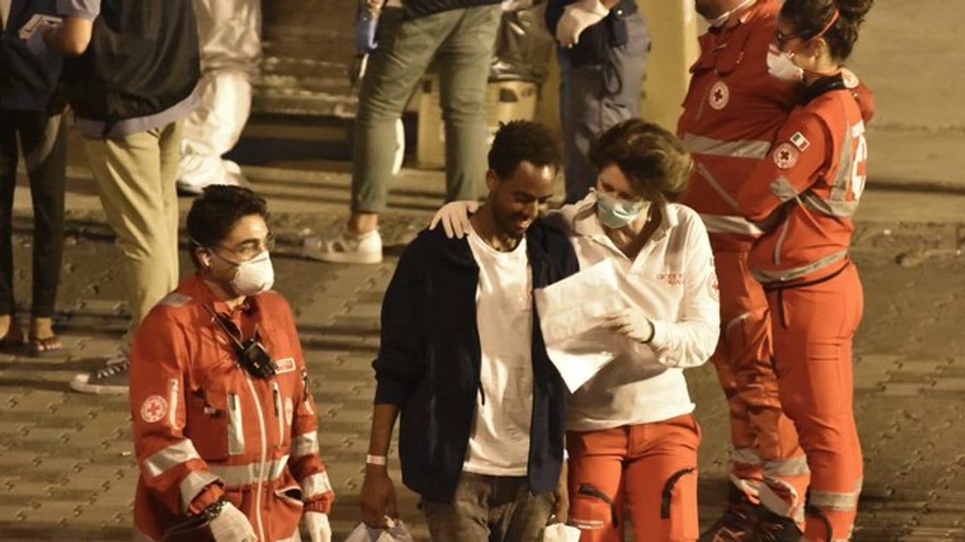 Ein Migrant spricht mit einer Helferin des Roten Kreuzes als er Bord der "Diciotti" geht.