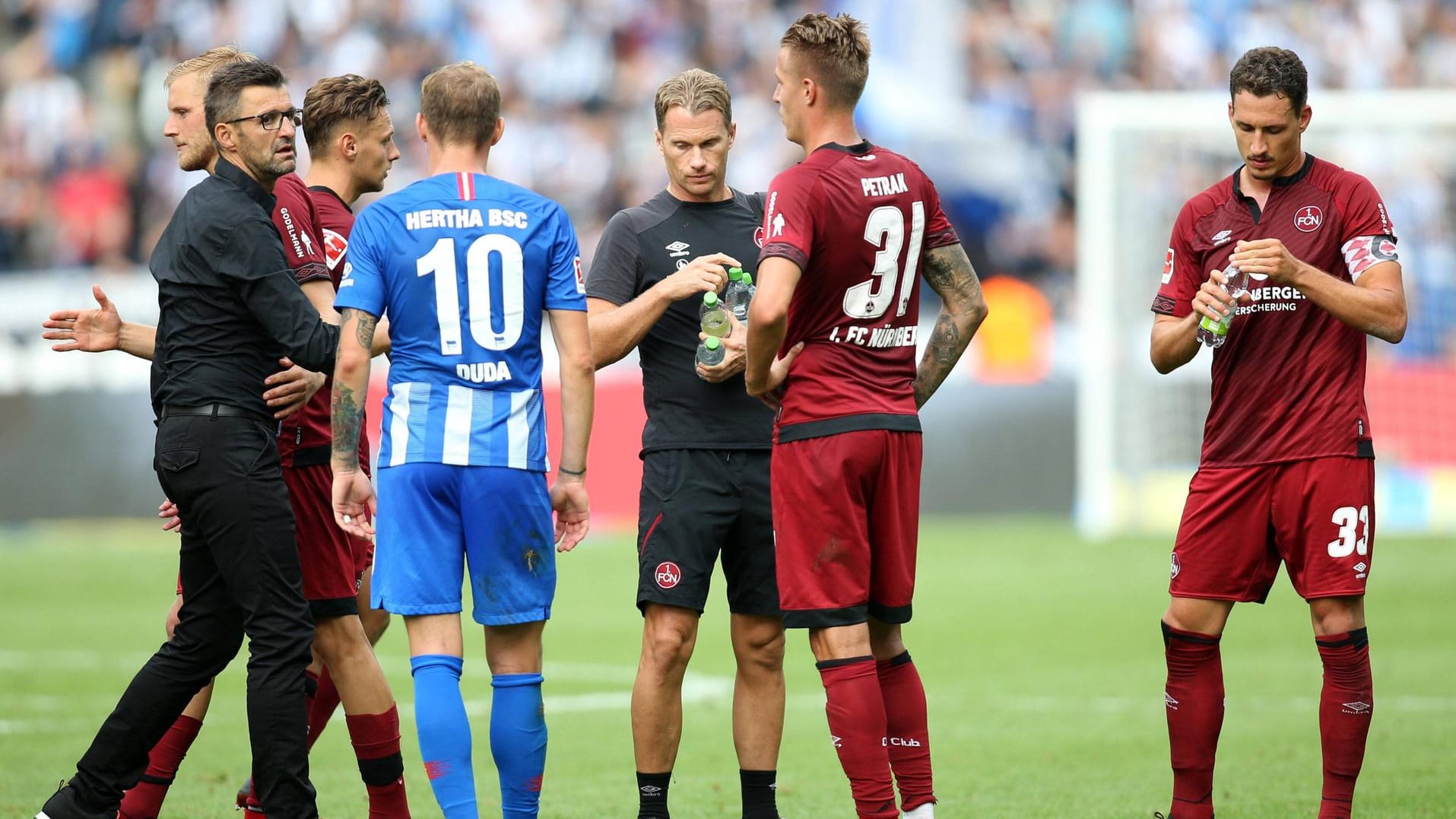 Nürnbergs Trainer Köllner (li.) nach dem Auftakt in Berlin mit seinen Spielern.