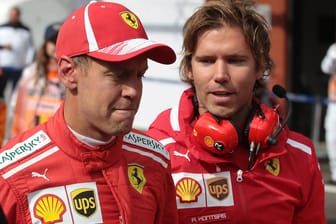 Angefressen: Sebastian Vettel (li.) auf dem Weg in die Ferrari-Box.