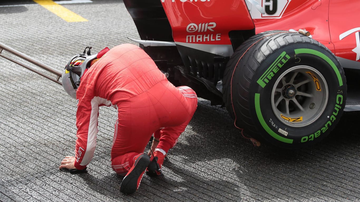 Prüfender Blick: Vettel checkt den Unterboden seines Ferrari.