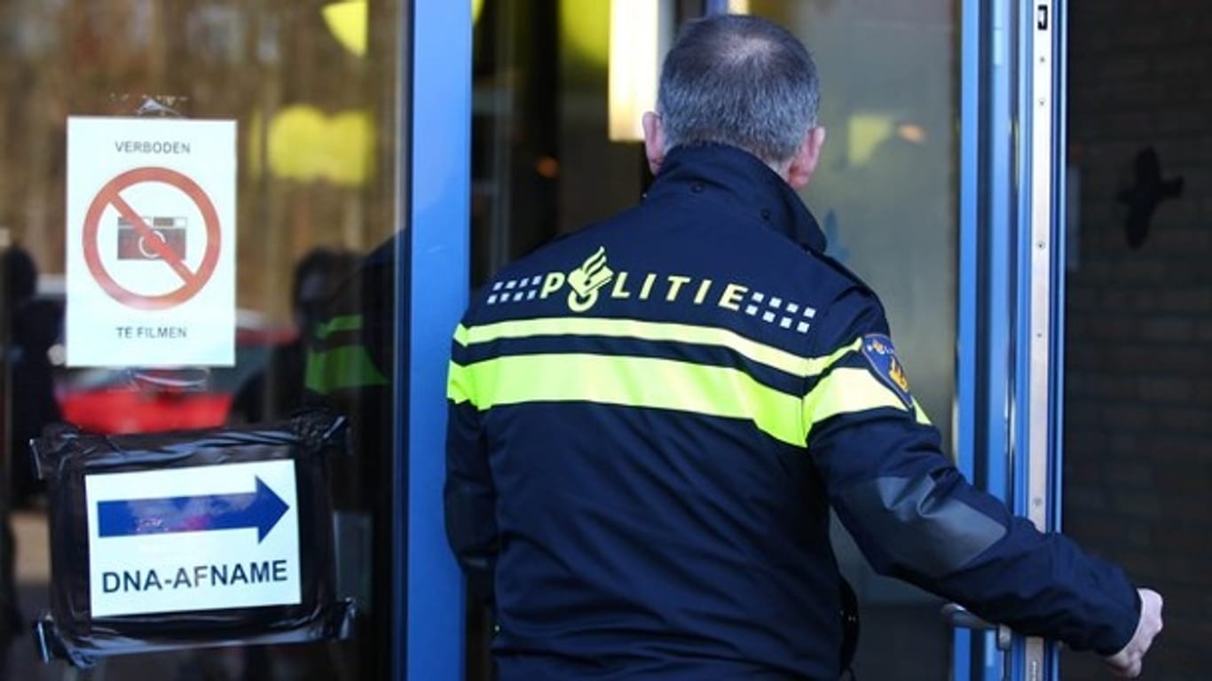 Ein niederländischer Polizist am Gebäude, in dem der DNA-Massentest stattfindet: Mehr als 14.000 Männer gaben in den Niederlanden eine DNA-Probe ab.