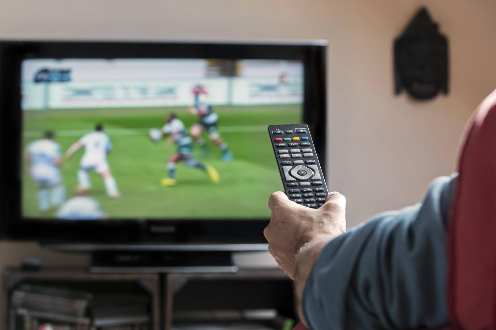 Ein Mann guckt Fußball: Unter anderem Fußball-Liveübertragungen werden über nicht offizielle Quellen aus dem Internet geschaut.