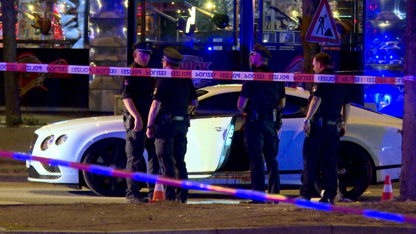 Polizisten stehen neben einem Auto auf dem Millerntorplatz, nachdem Schüsse gefallen sind: Der schwerverletzte Angeschossene kam ins Krankenhaus.