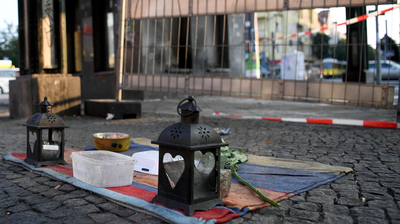 Kerzen und eine Rose von Passanten liegen auf einer Decke, wo zwei Obdachlose angezündet wurden: In vielen Fällen kommt es wahrscheinlich gar nicht erst zur Anzeige. (Archivbild)