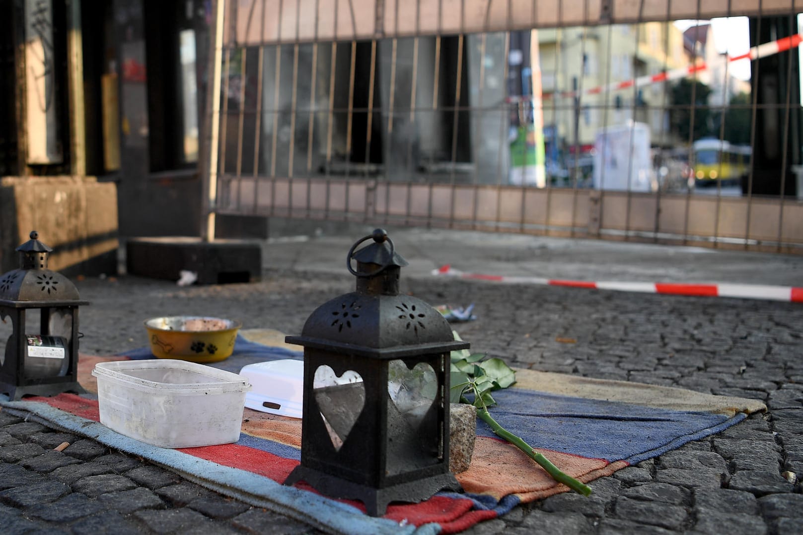 Kerzen und eine Rose von Passanten liegen auf einer Decke, wo zwei Obdachlose angezündet wurden: In vielen Fällen kommt es wahrscheinlich gar nicht erst zur Anzeige. (Archivbild)