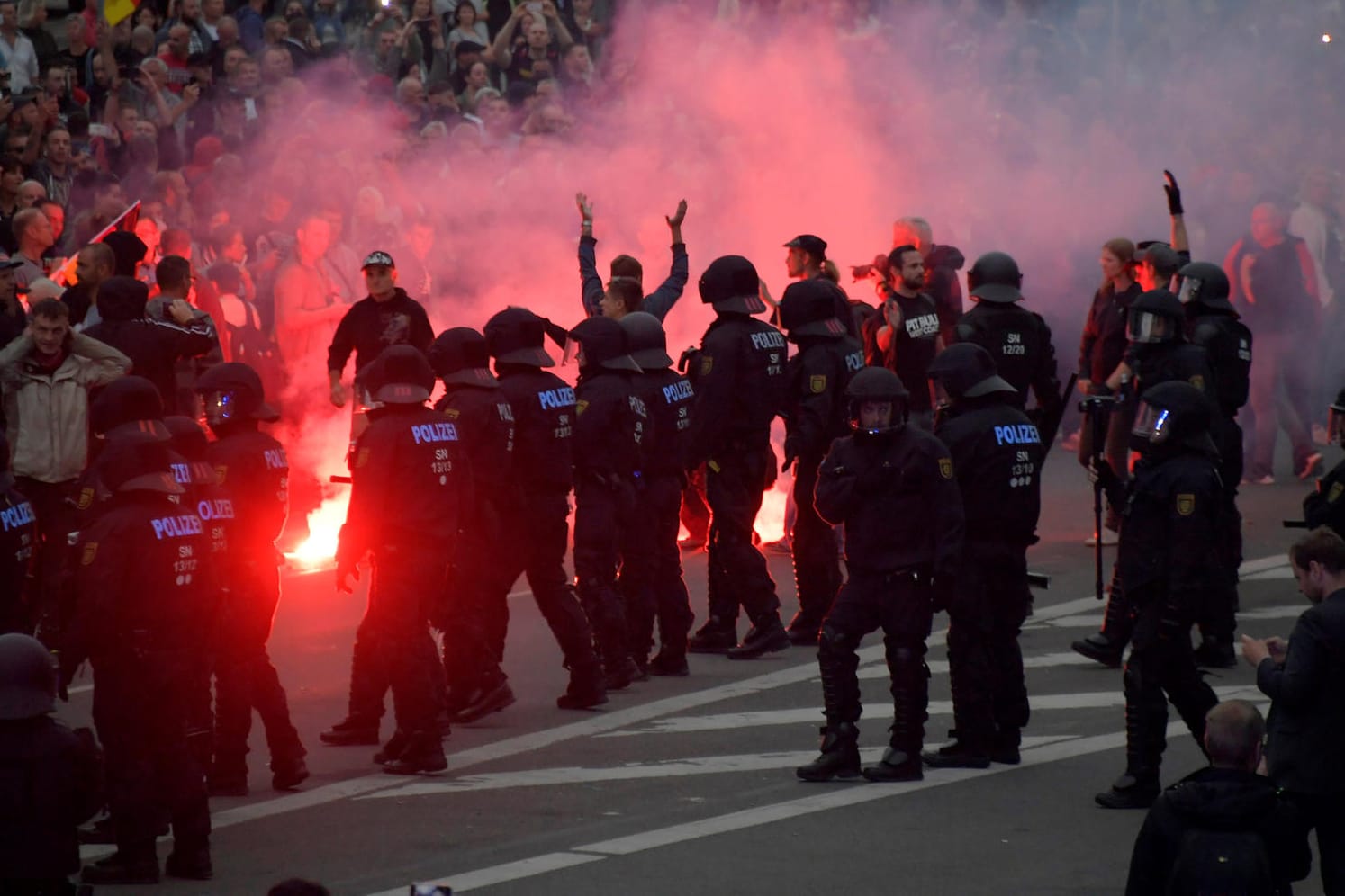 Teilnehmer der rechten Kundgebung zünden Feuerwerkskörper: Am Tag nach den rechtsextremen Ausschreitungen treffen in Chemnitz rechte und linke Demonstranten aufeinander.