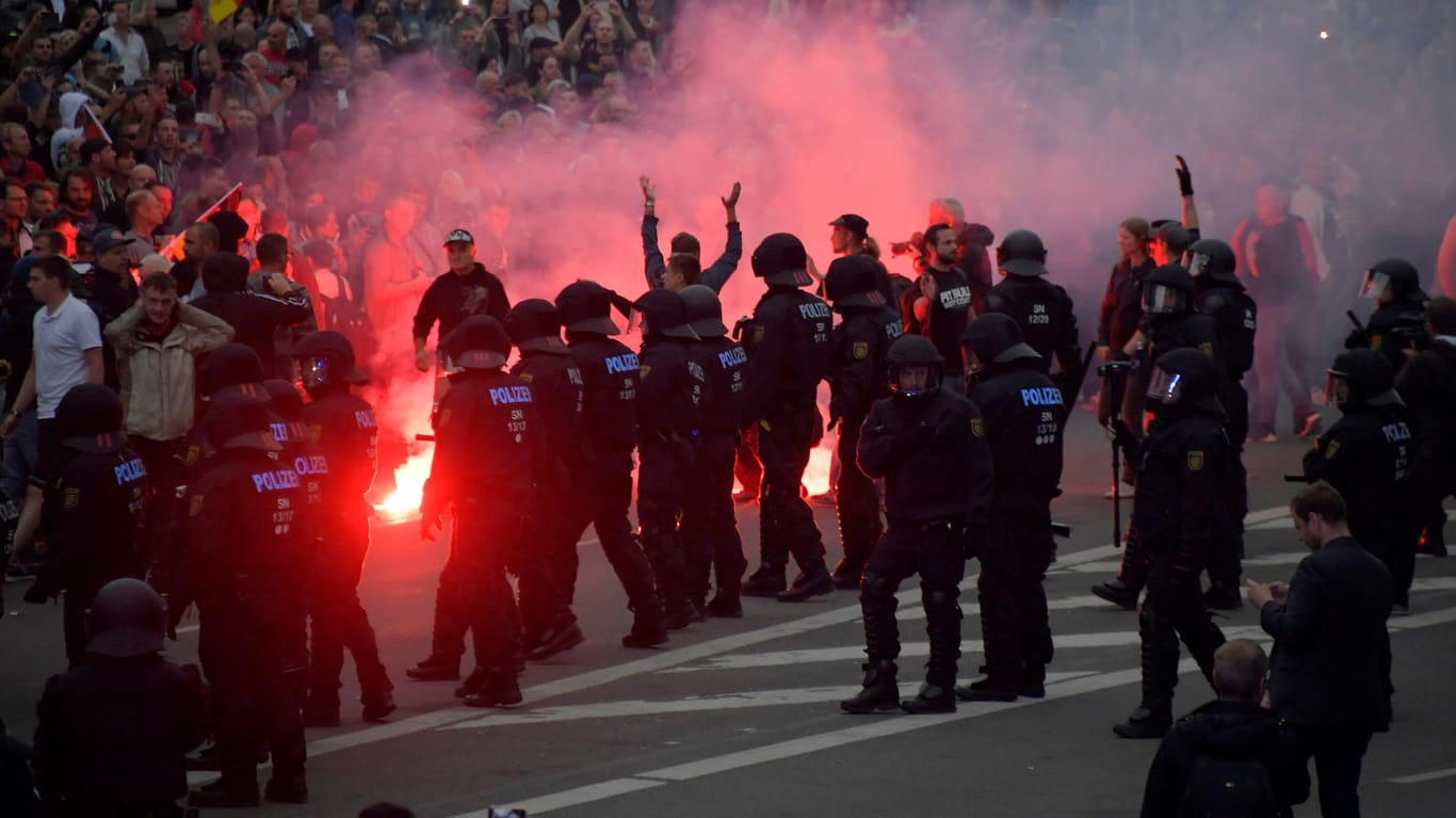 Teilnehmer der rechten Kundgebung zünden Feuerwerkskörper: Am Tag nach den rechtsextremen Ausschreitungen treffen in Chemnitz rechte und linke Demonstranten aufeinander.