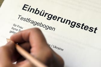 Eine Person füllt einen Einbürgerungstest aus: Mit dem Quiz von t-online.de können Sie den Test online ausprobieren.
