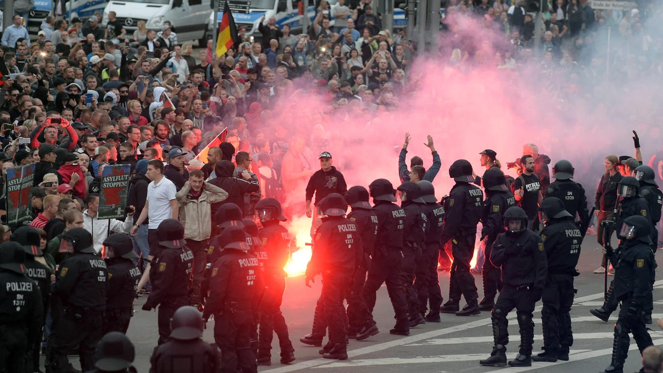 Rechte Demonstranten zünden Pyrotechnik: Bei den Ausschreitungen in Chemnitz gibt es mindestens 20 Verletzte.