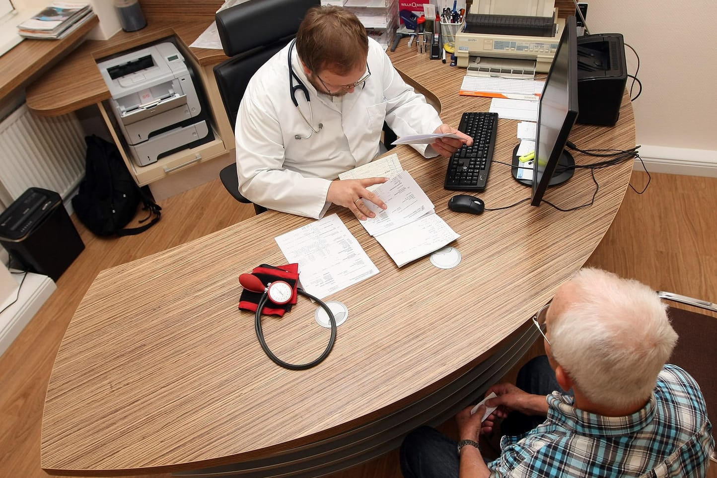 Ein Arzt empfängt einen Patienten in seinem Sprechzimmer: Vor allem bei Fachärzten müssen Patienten mit langen Wartezeiten rechnen.