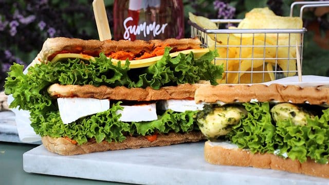 Das Sandwich schmeckt in beiden Varianten: einmal belegt mit Camembert, Gouda und Tomatenbutter, das andere Mal mit einer Kombi aus Pesto und Hühnchen.