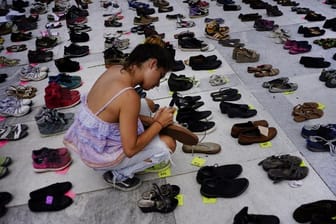 In San Juan auf Peurto Rico orndet ein Frau Schuhpaare, die an die Opfer des Hurrikans "Maria" erinnern sollen.