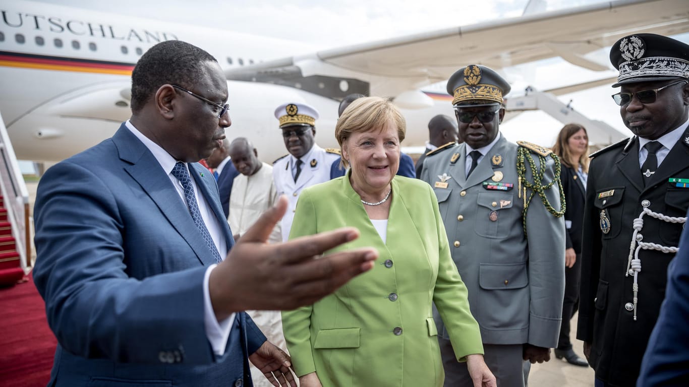 Angela Merkel (CDU) wird von Macky Sall, dem Präsidenten der Republik Senegal, am Flughafen begrüßt: Für die Kanzlerin geht es in Afrika um nicht weniger als ihre Kanzlerschaft.