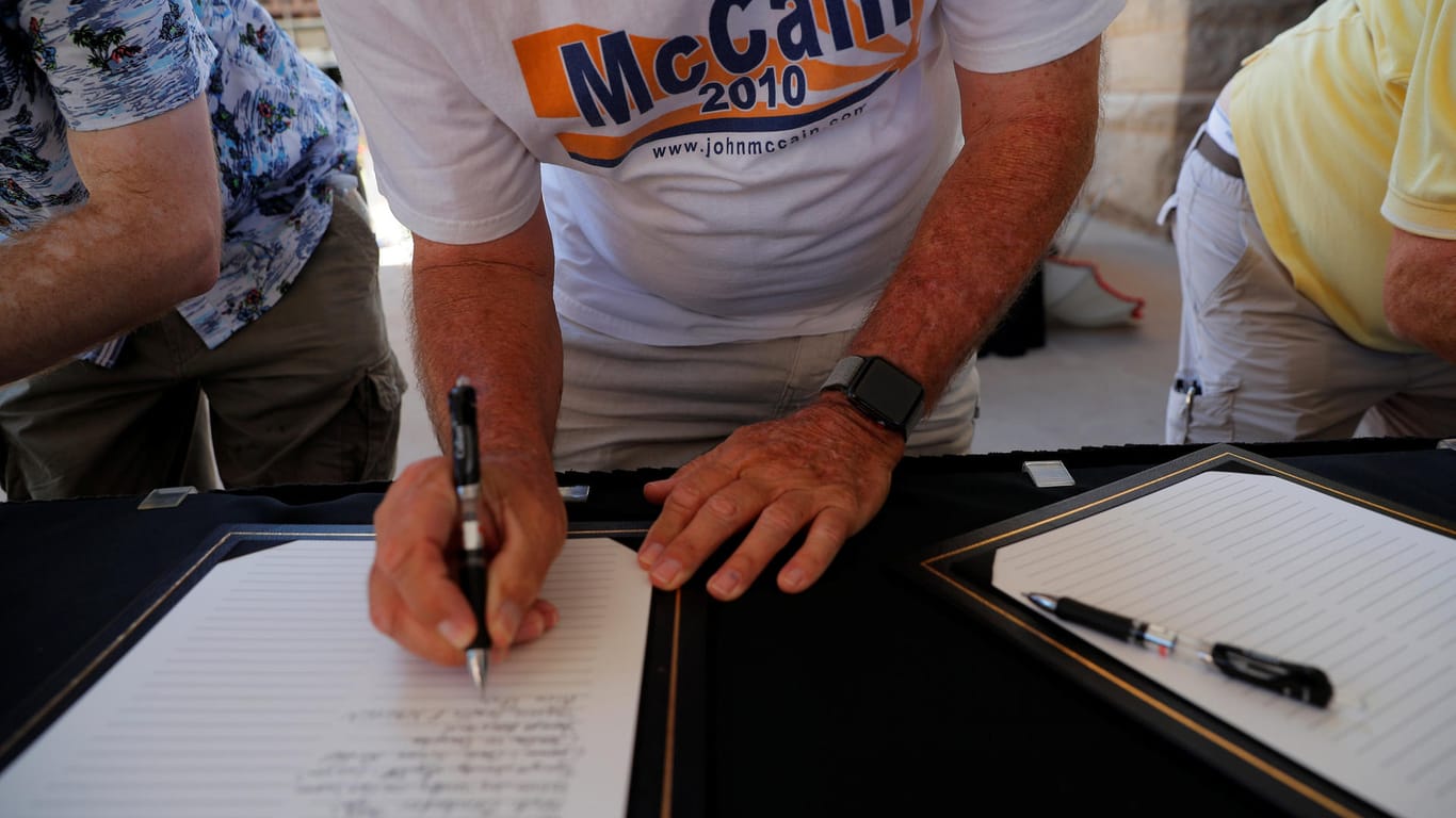Ein Unterstützer hinterlässt eine Nachricht in dem öffentlichen Kondolenzbuch von McCain.